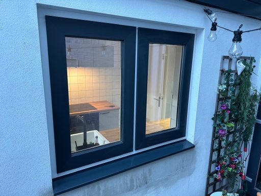 Kozijnplaatsing in Tilburg Dubbele ramen met zwart frame, uitzicht op een keuken met zachte verlichting.