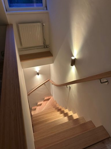 Trap renovatie in Helvoirt Houten trap met wandlampjes die leiden naar beneden in een lichte omgeving.