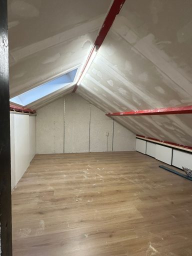 Zolderaftimmering in 's-Hertogenbosch Lege zolderruimte met houten vloer en gevelramen, afgewerkt met schilderwerk.